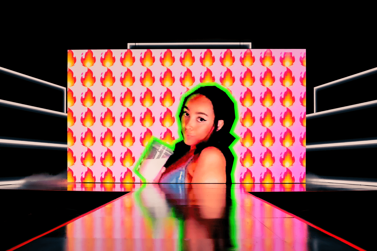 Screen showing a person against a pink flame-emoji pattern with a glitchy green and red outline effect.