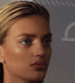 Close-up profile portrait of a blonde woman with slicked-back hair.