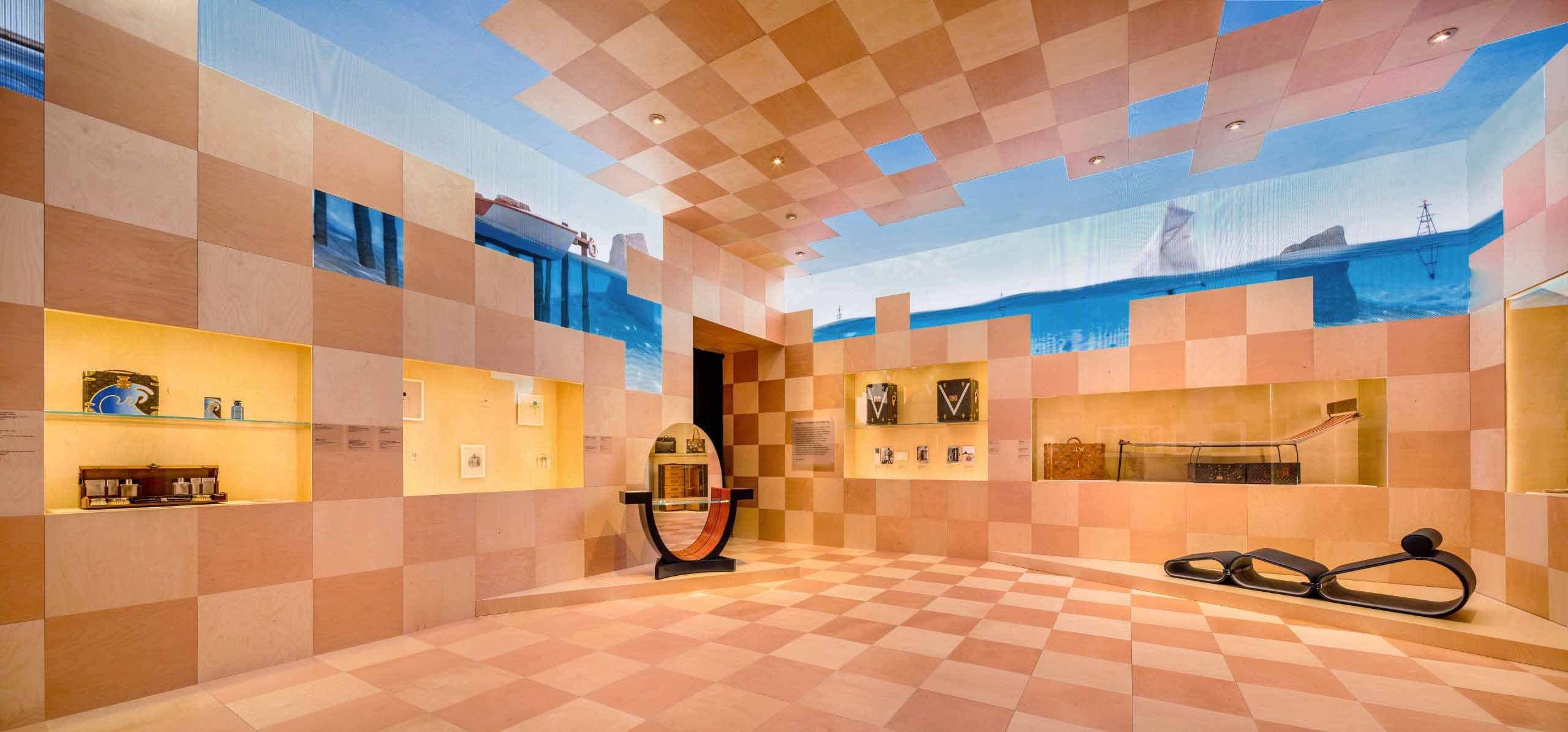 Empty exhibition room with a checkerboard-patterned floor, walls, and ceiling.