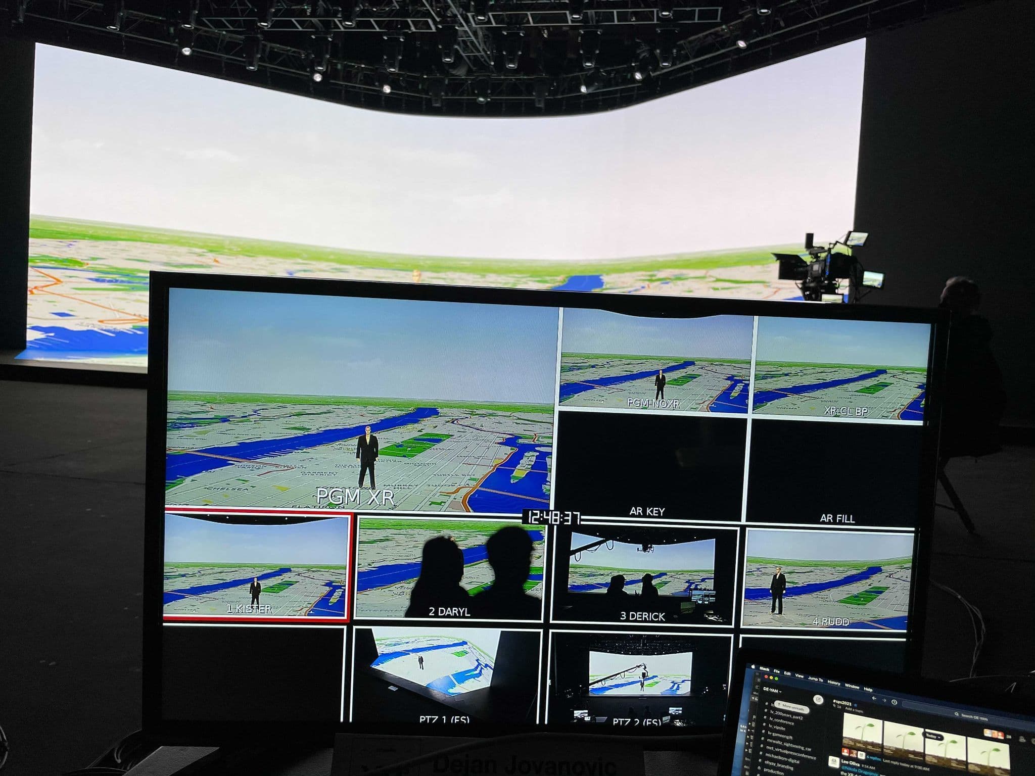 Green-screen studio with multiple monitors showing a live augmented reality composite.